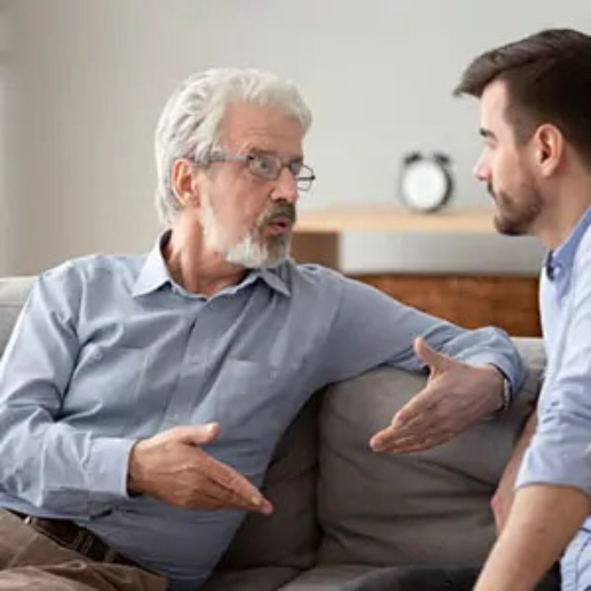 Two businessmen sitting on sofa talking