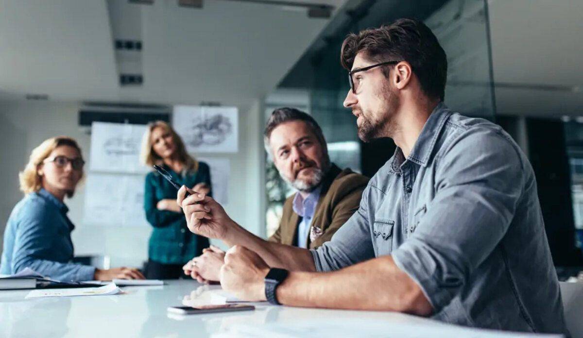 Businesspeople sat around table in meeting discussing