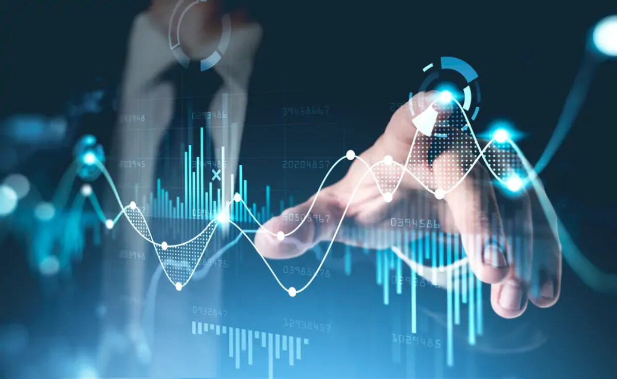 Businessman pointing at overlaid graph images