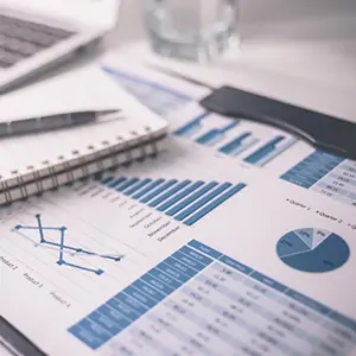 Notebook and document showing graphs and charts on desk