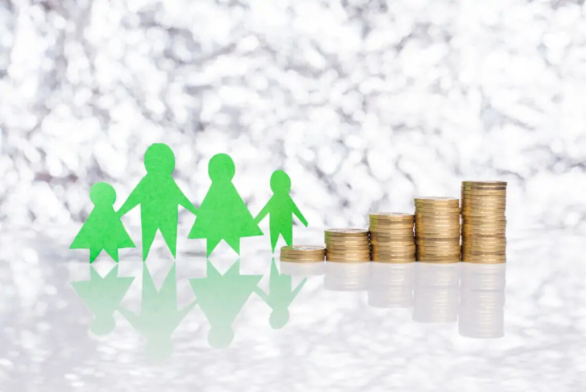 Paper cutout representing a family next to increasingly tall stacks of coins