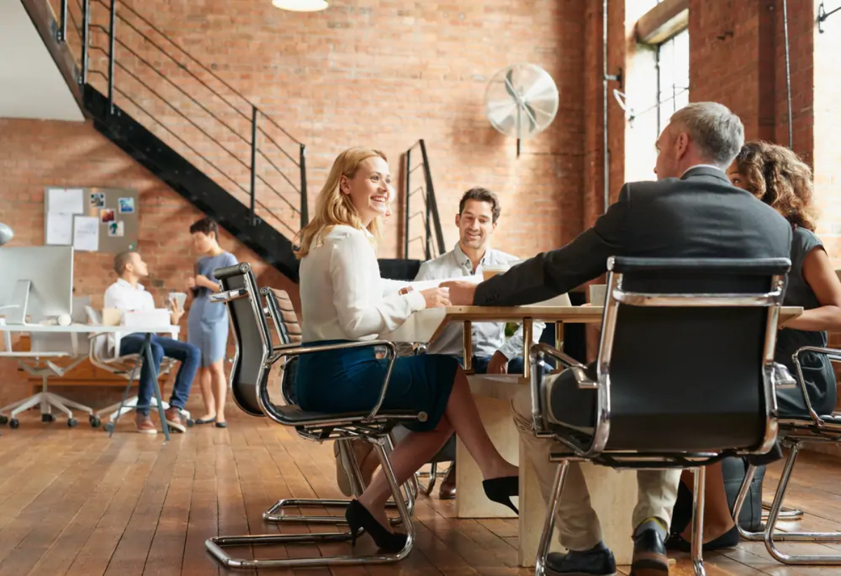 Businesspeople sitting around table at meeting in modern office