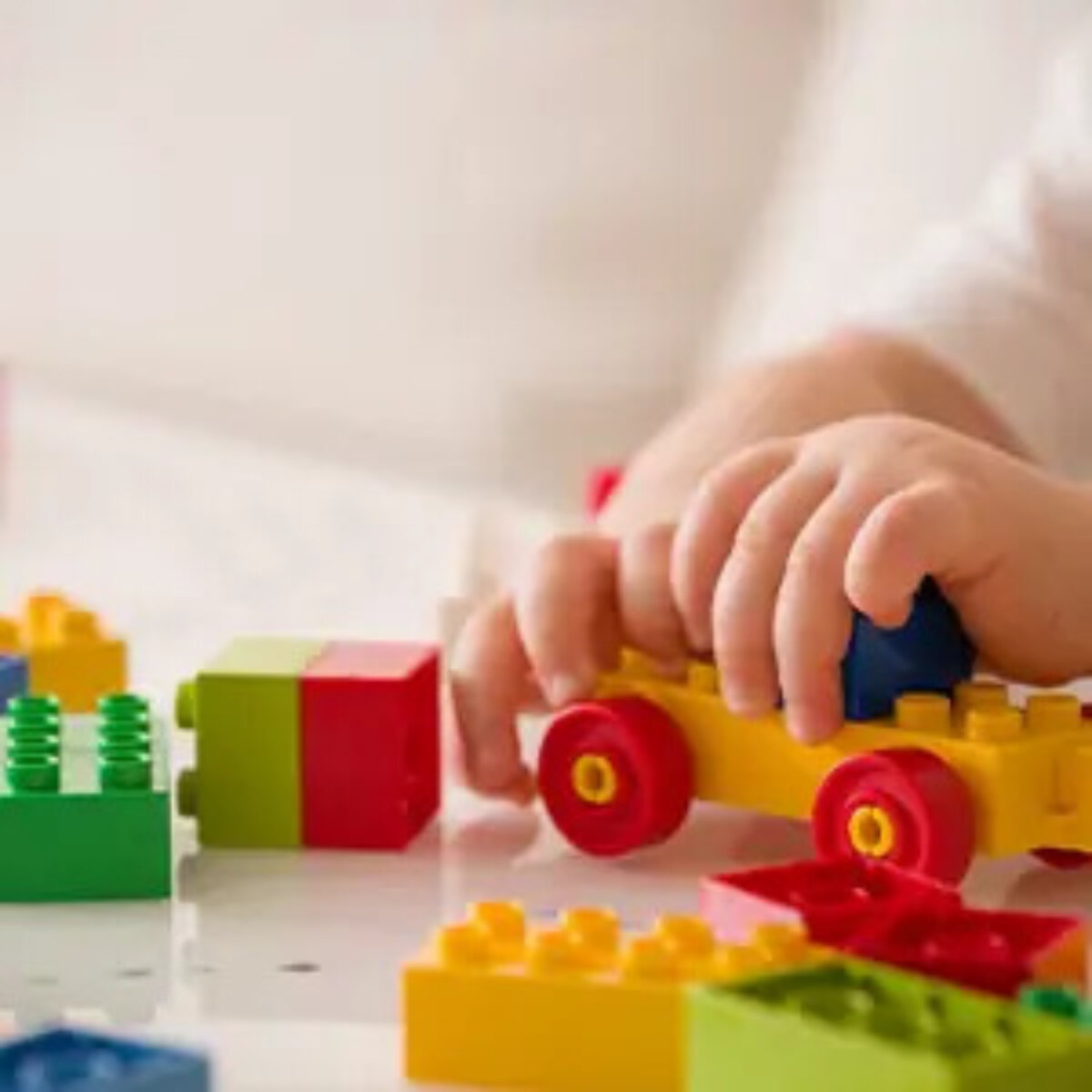 Child playing with Lego at table