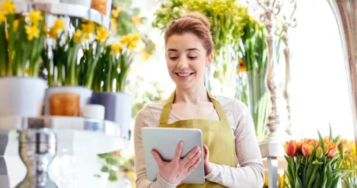 Woman working in florist shop using tablet