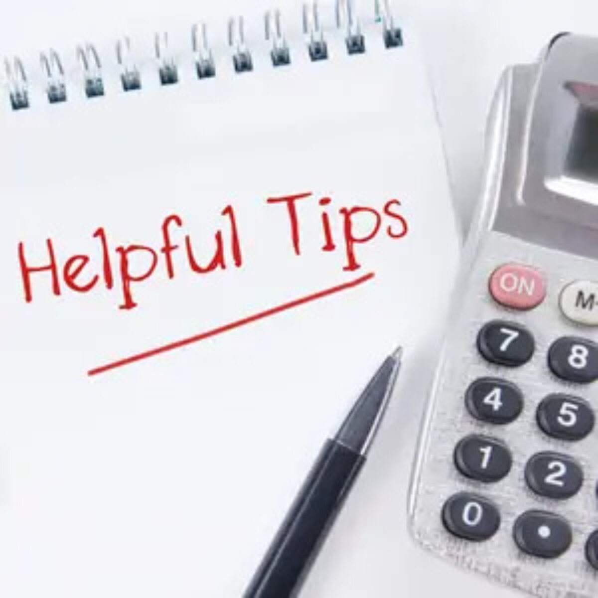 Open notebook with 'helpful tips' written on page and pen and calculator on top