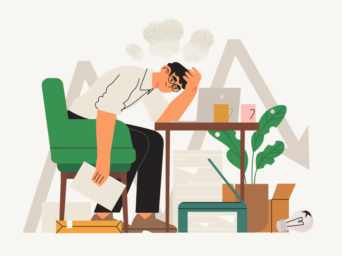 Cartoon of businessman sitting at desk with head in hand and other hand holding a document