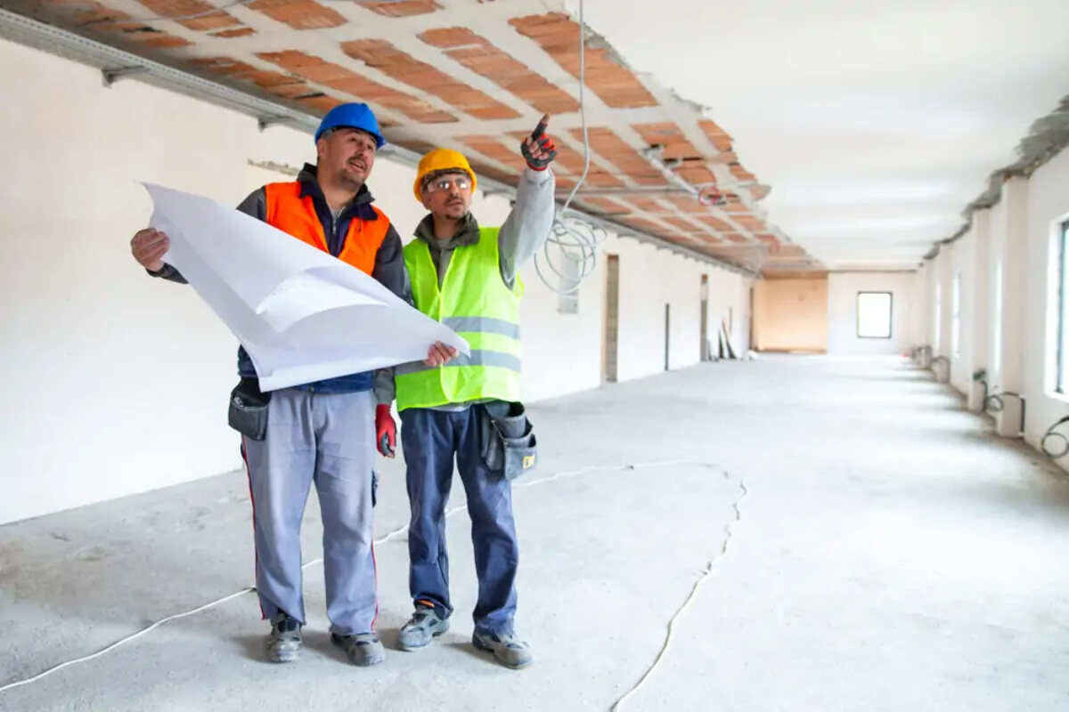 Two construction subcontractors at a building site discussing plans