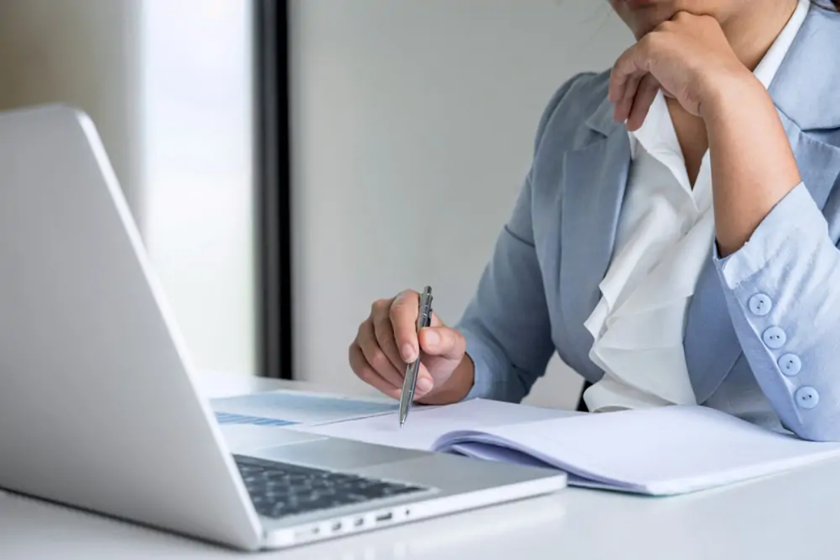 Businesswoman sitting at laptop trying to comply with Making Tax Digital