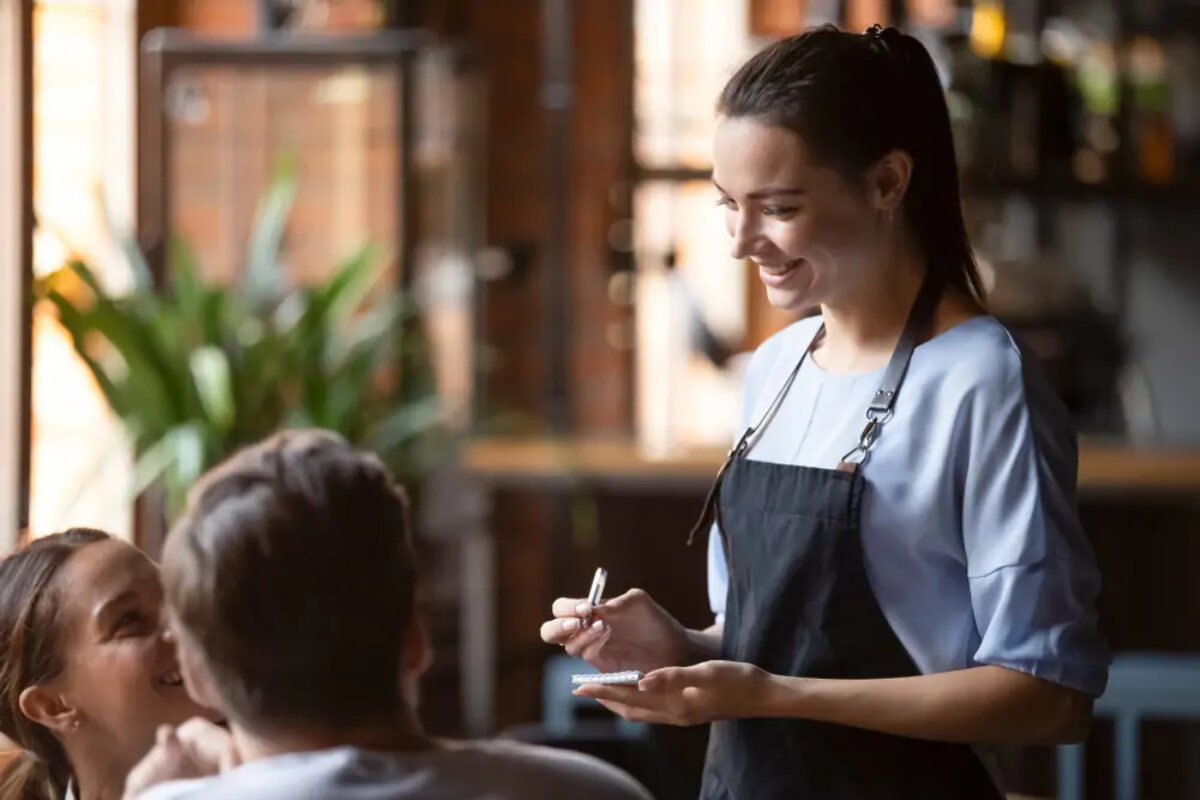 Waitress taking customers' orders at table