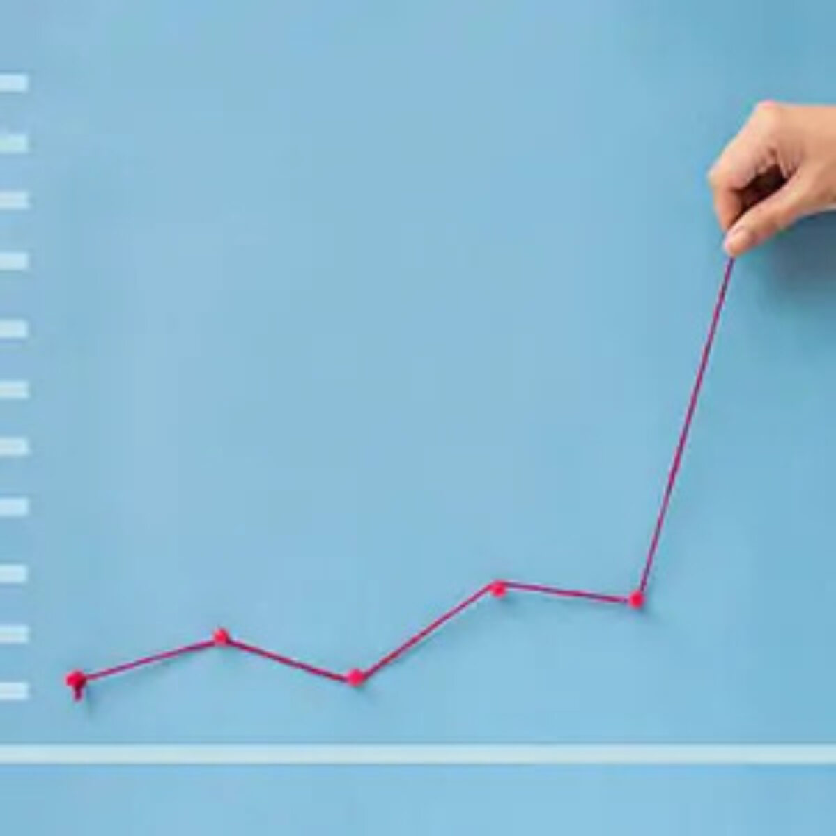 Hand making line graph from pin tacks and string