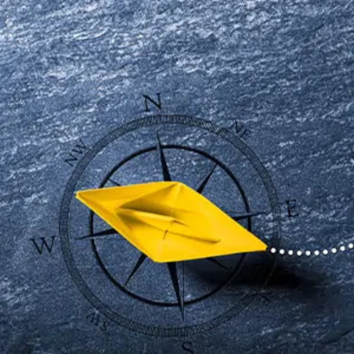 Model boat made from yellow paper on top of a compass face background with a dotted trail behind it