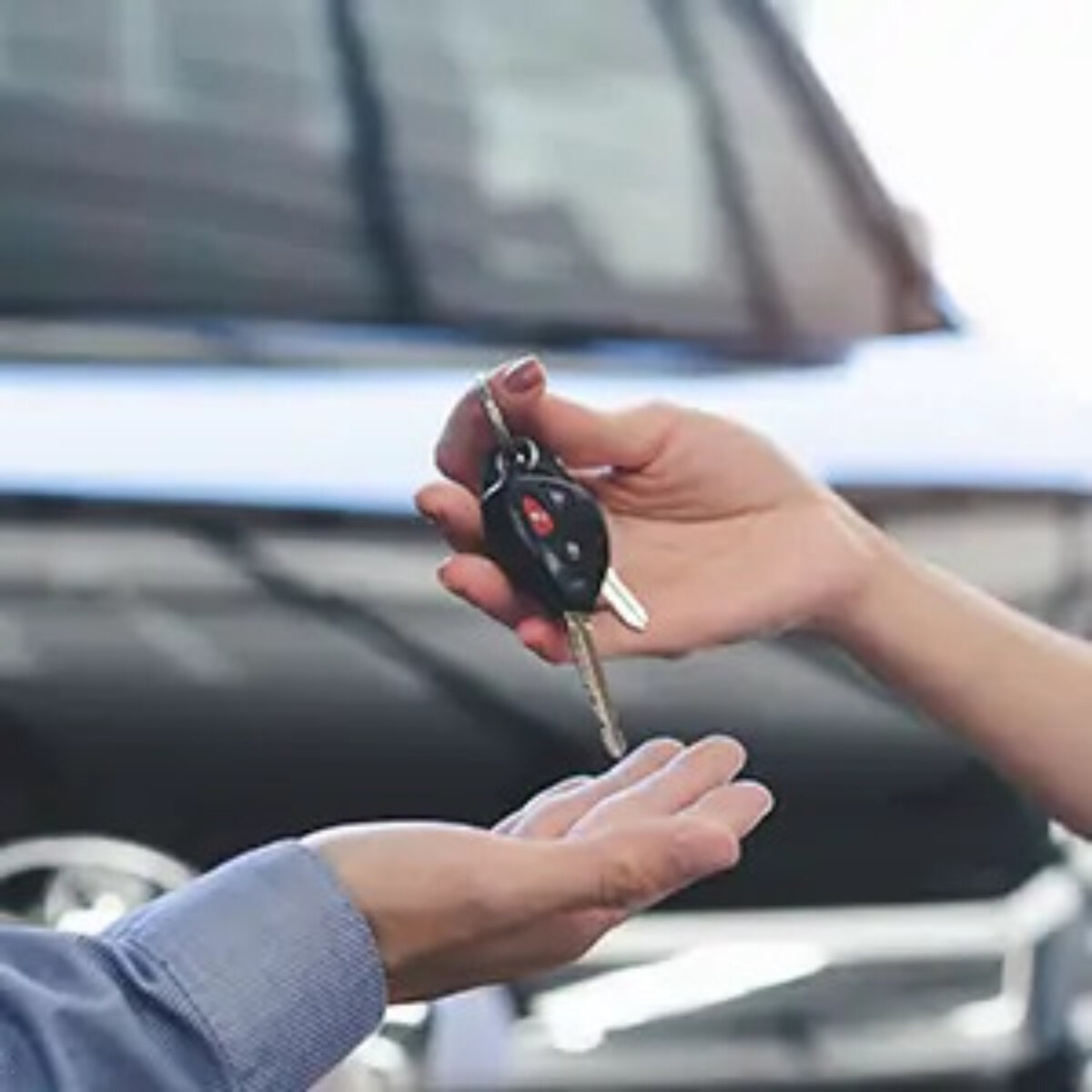One person handing over a set of car keys to another