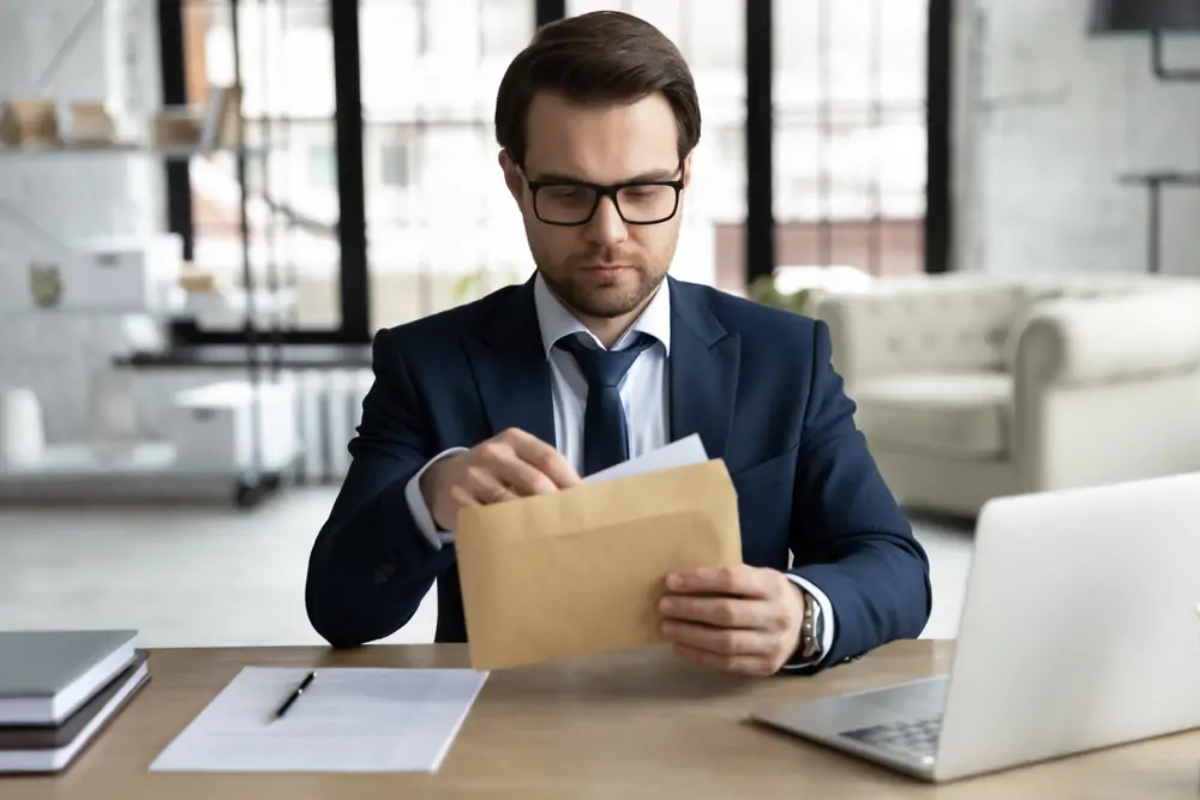 Businessman at desk opening HMRC letter