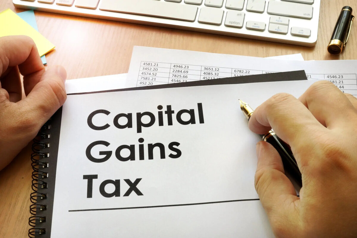 Hands around document with title 'Capital Gains Tax'