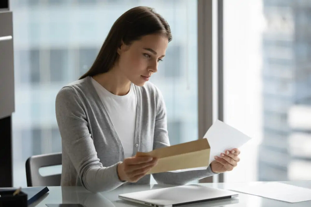 Businesswoman reading letter at desk