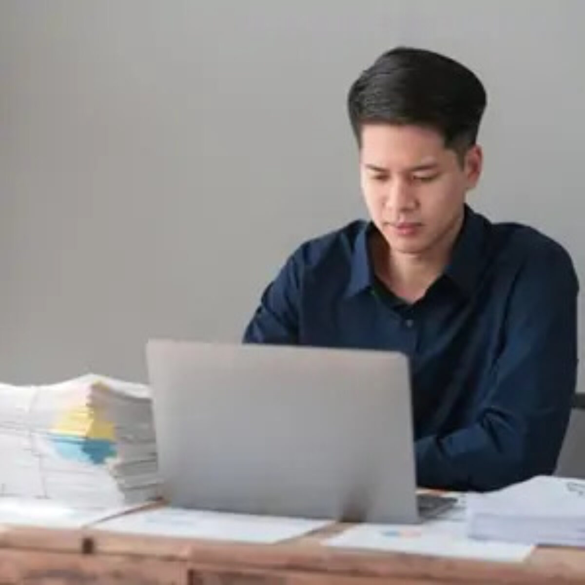 Businessman at desk working on laptop to prepare for payroll year-end