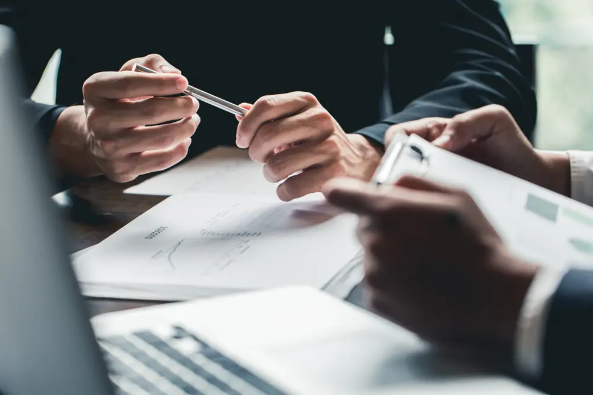 Two businessmen at table looking at printed documents