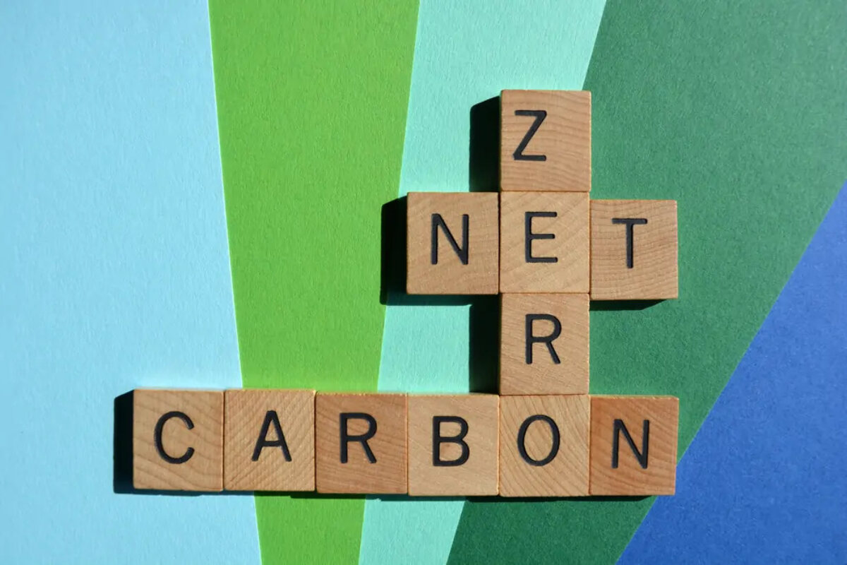 Wooden scrabble-style tiles arranged in various directions spelling out 'net zero carbon'