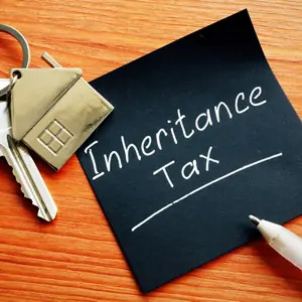 Post-it note with 'inheritance tax' written on it next to a key with a house keyring