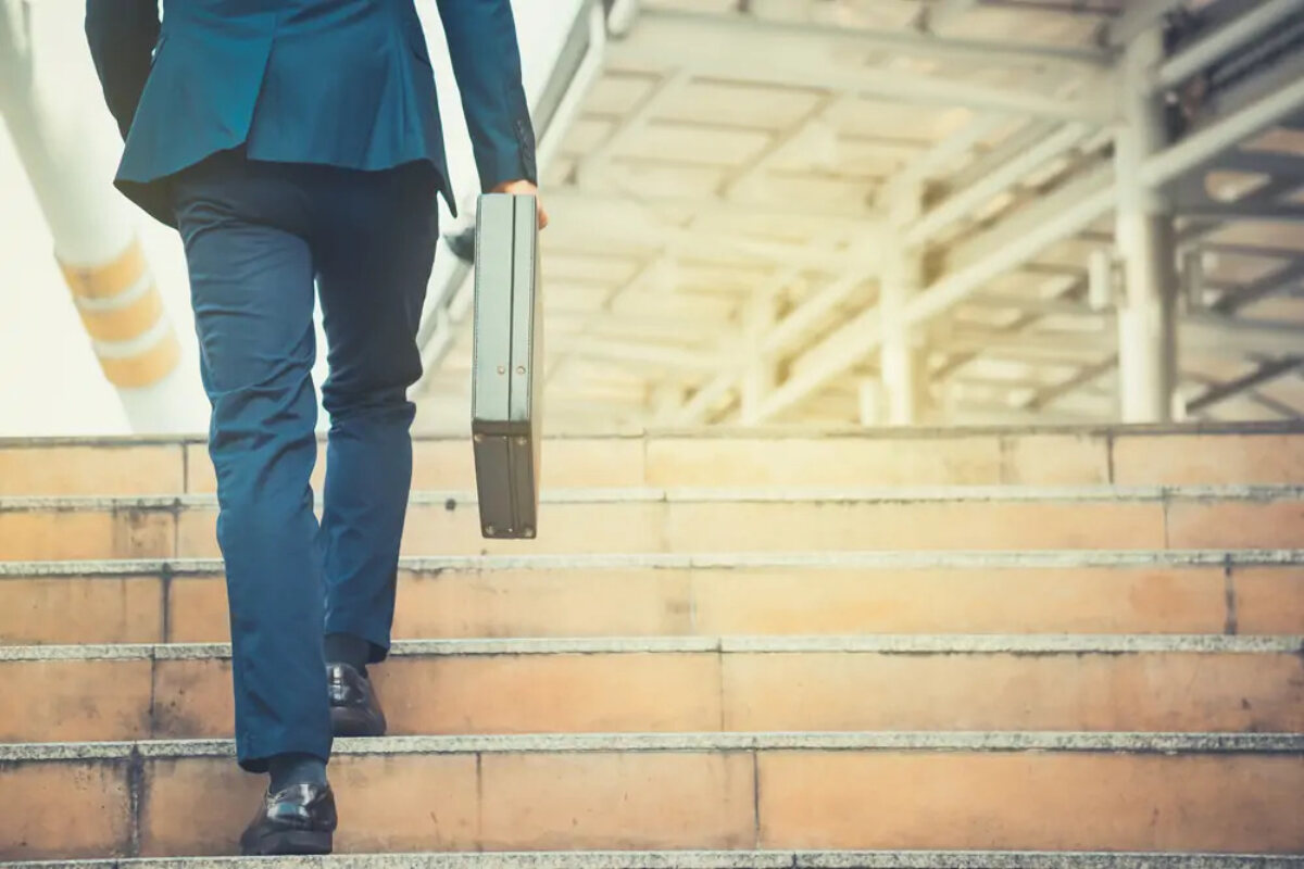 Businessman holding briefcase walking up stairs