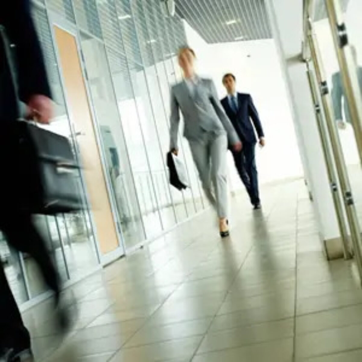 Two business people walking down an office corridor