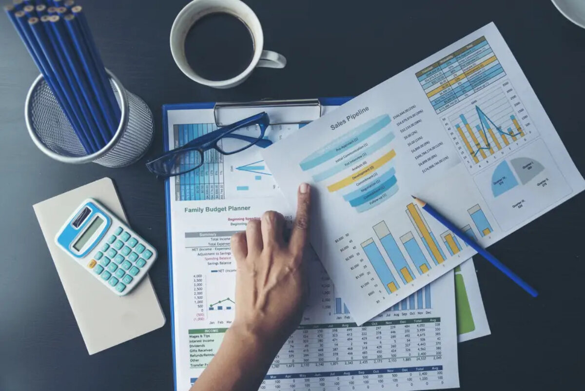 Businessperson pointing at documents showing sales numbers and budget plans