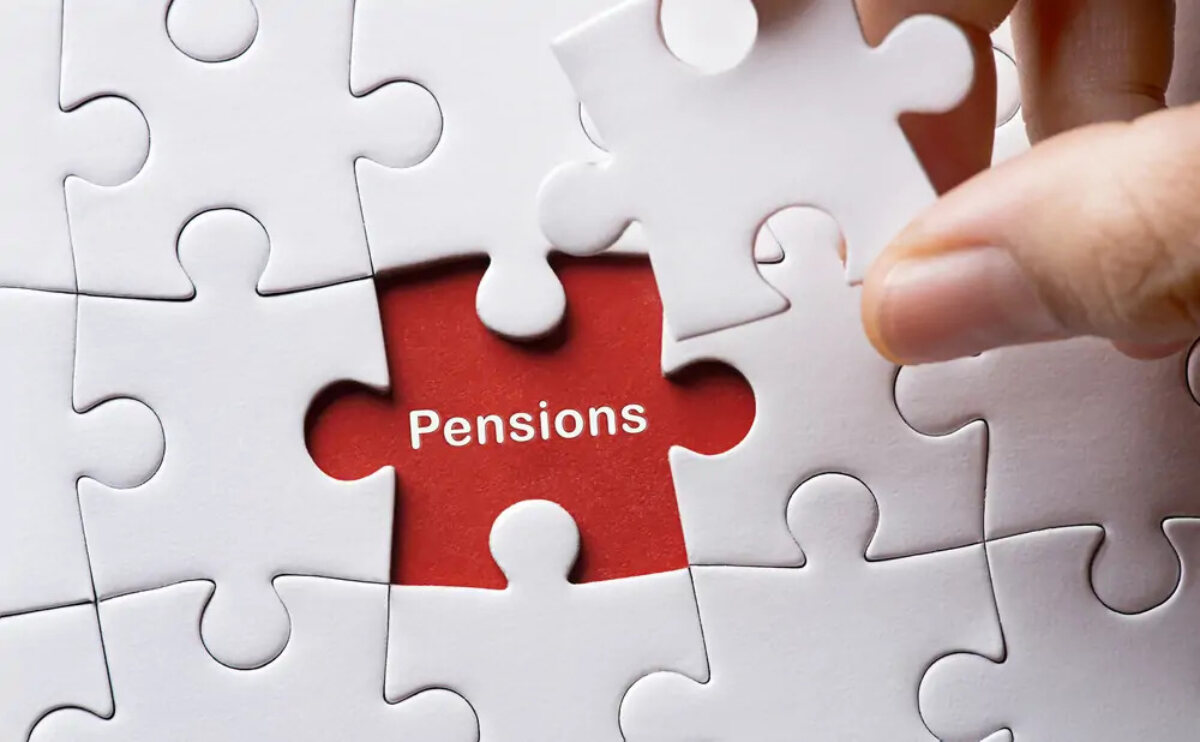 Hand holding last remaining jigsaw piece with the word 'Pensions' in the gap