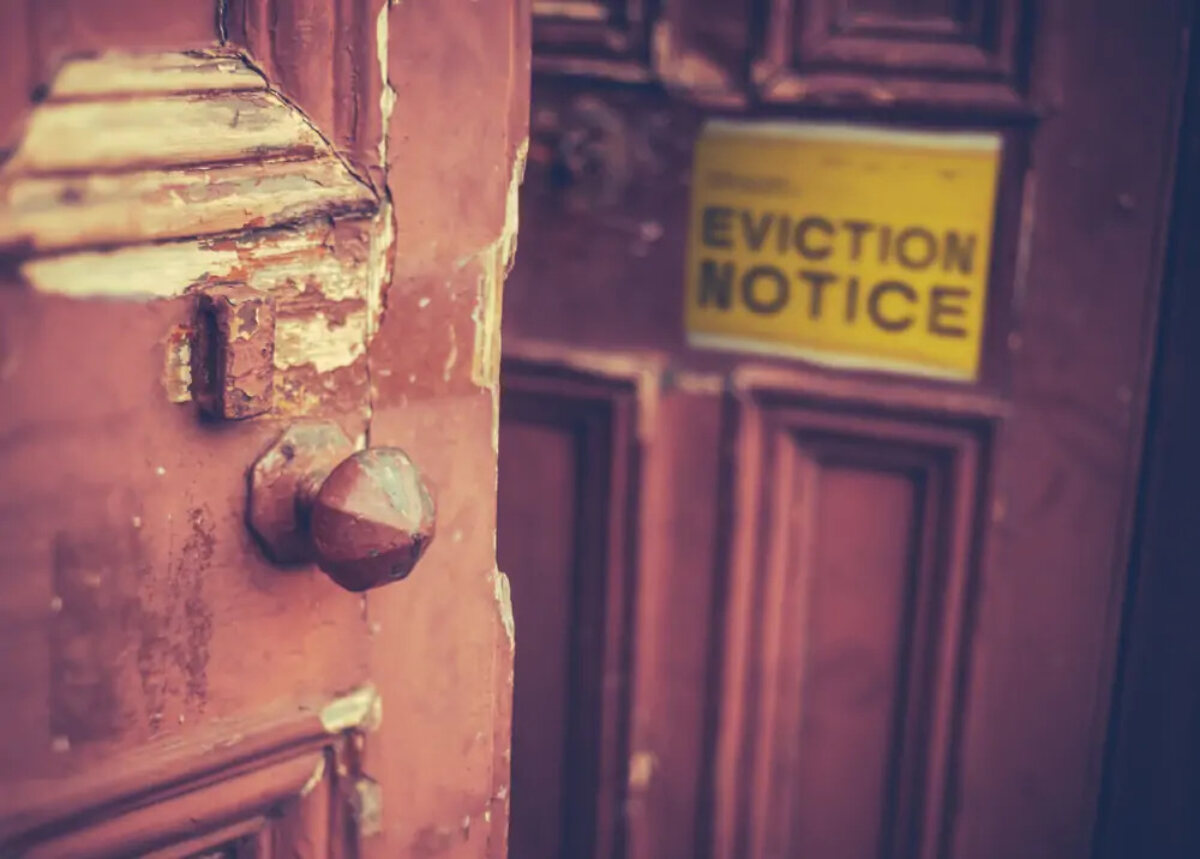 Double doors, one open one closed, with 'eviction notice' sign on front