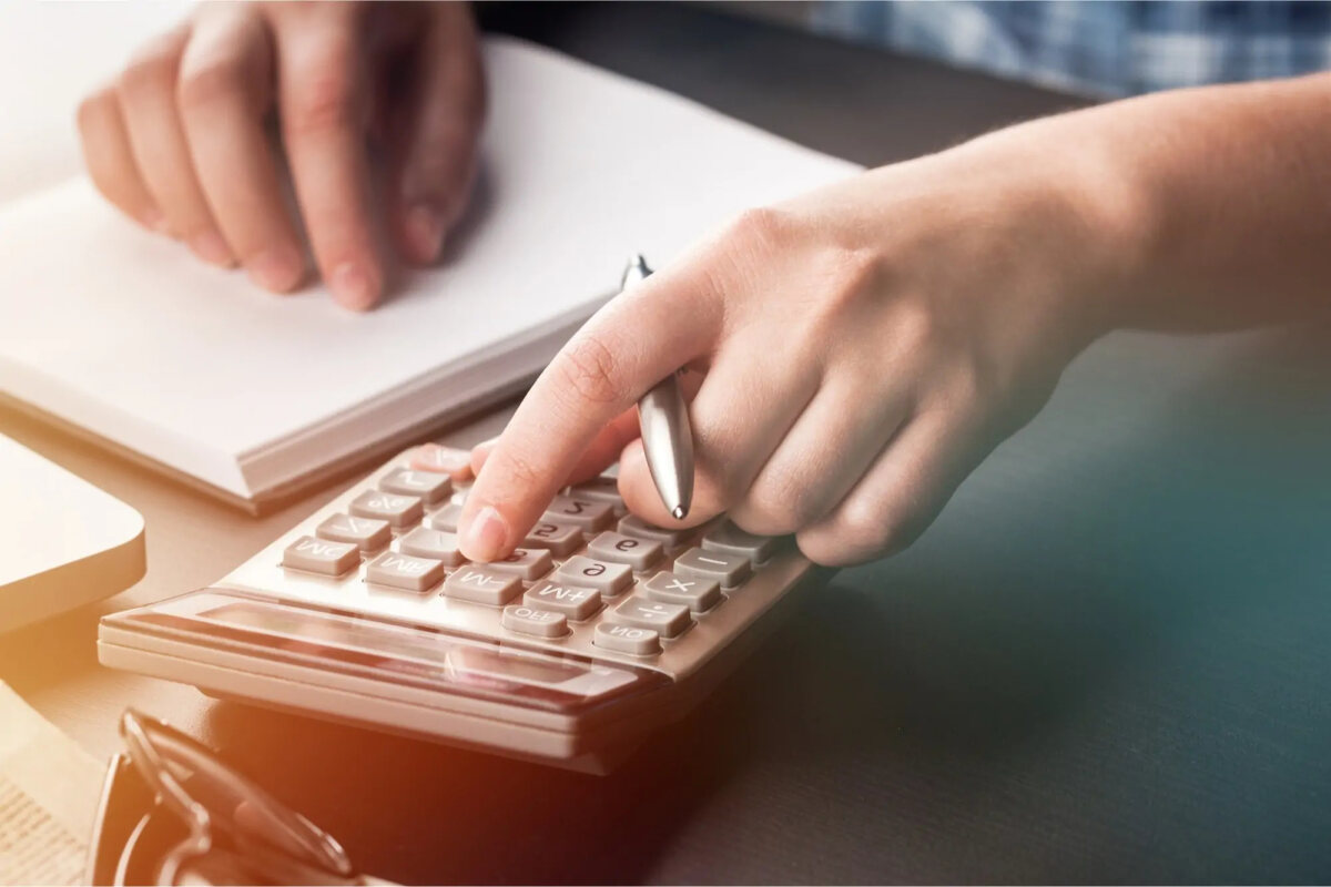 Hand holding a pen and using a calculator
