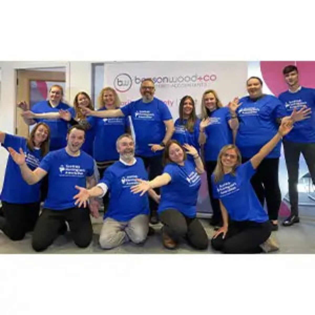 Benson Wood & Co team posing in the office wearing Scottish Huntington's Association t-shirts