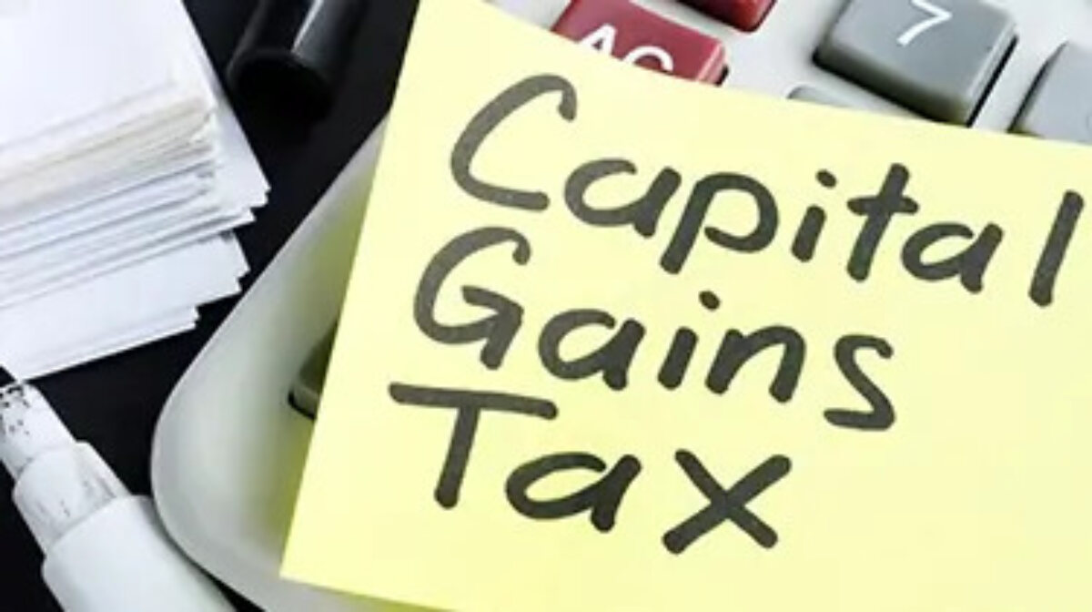 Post-it note on top of a calculator with 'Capital Gains Tax' written on it