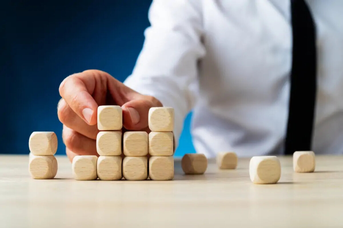 Businessman stacking wooden dice-shaped cubes to look like a bar chart