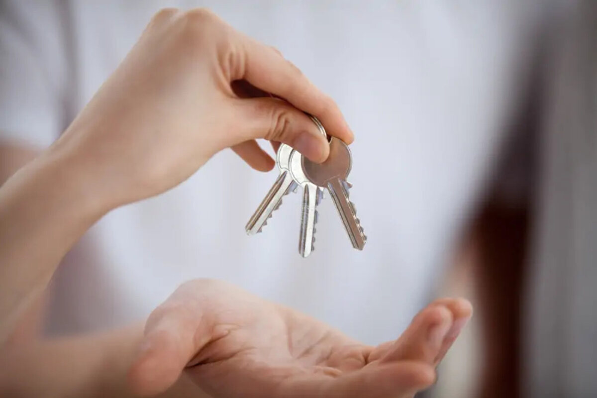 One person handing over set of three keys to another