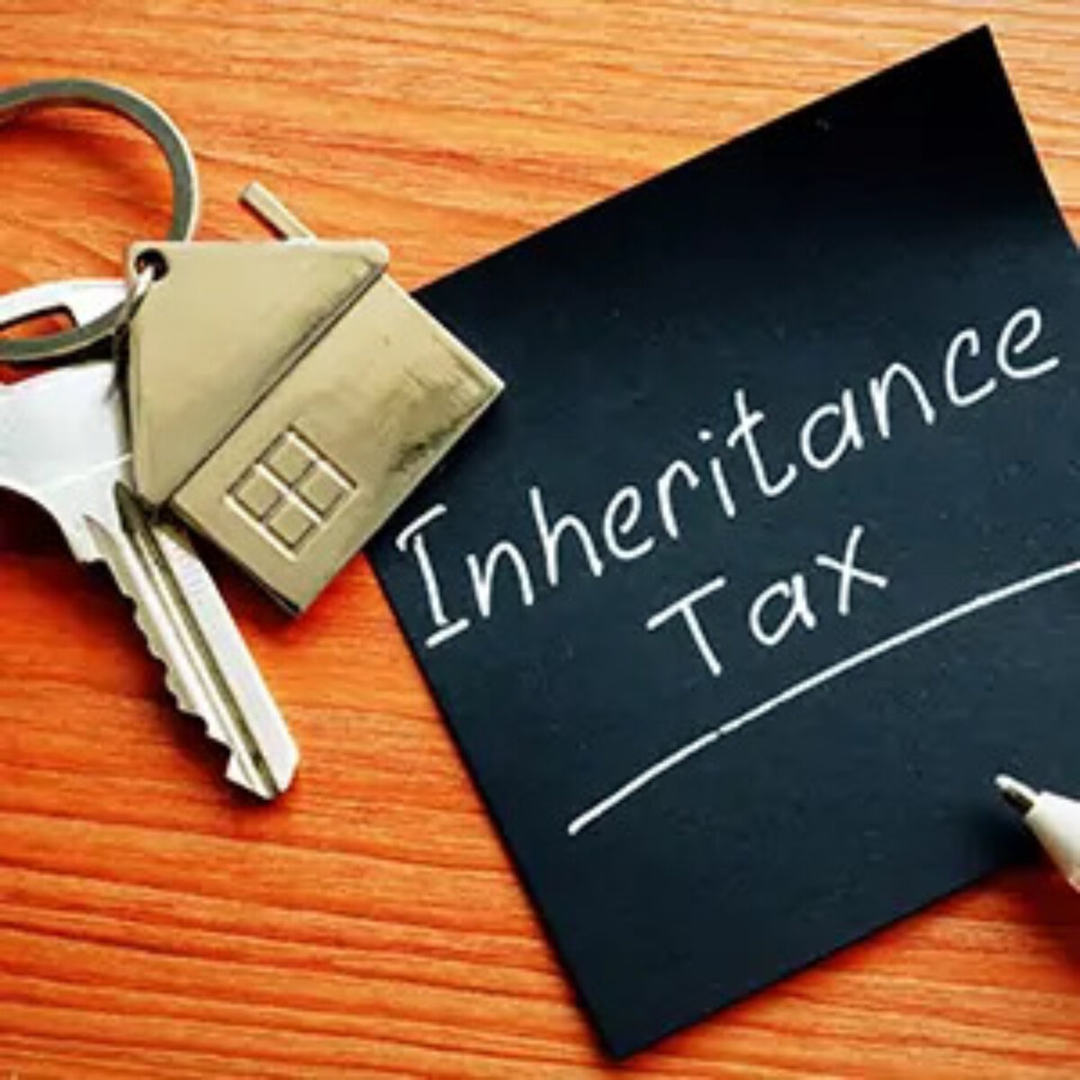 Post-it note with 'inheritance tax' written on it next to a key with a house keyring