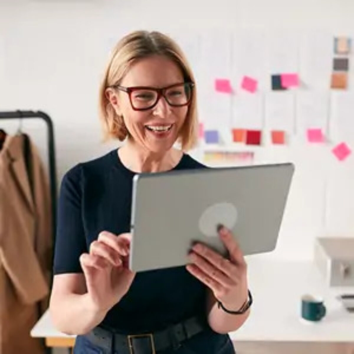 Businesswoman holding tablet and smiling at it