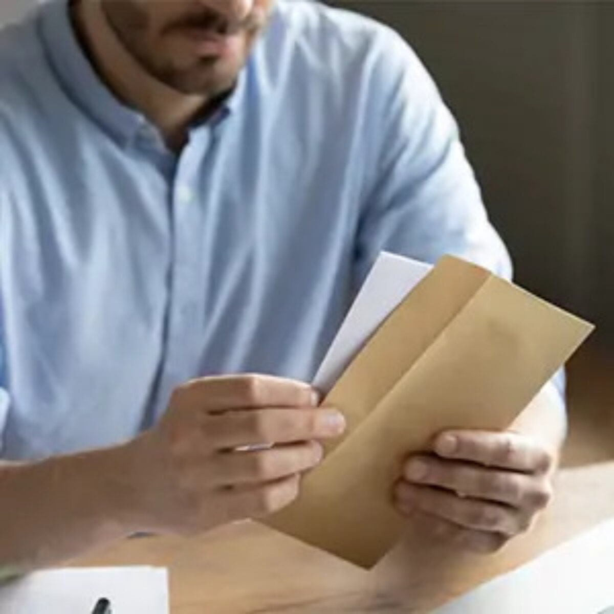 Businessman at desk opening letter
