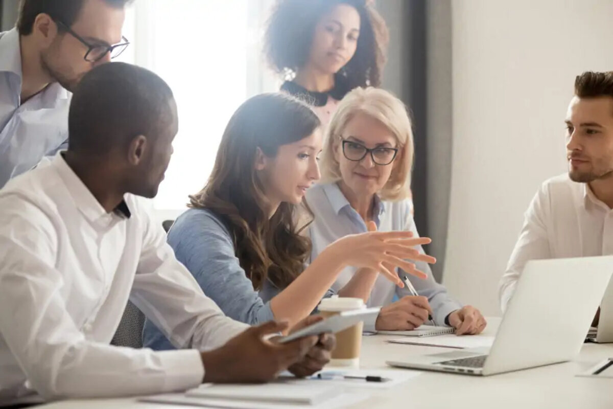 Businesspeople gathered around desk discussing business growth