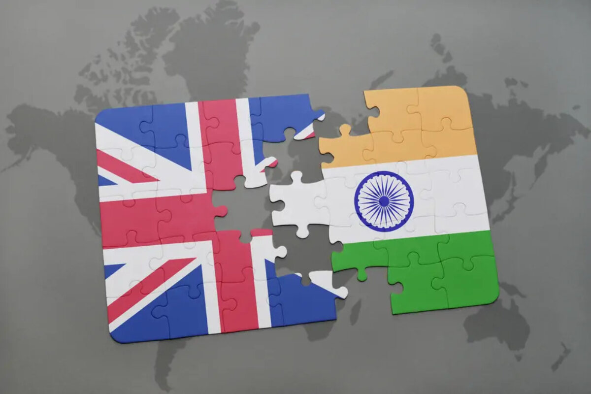 Almost completed jigsaw split down middle with UK flag on one side and India flag on the other
