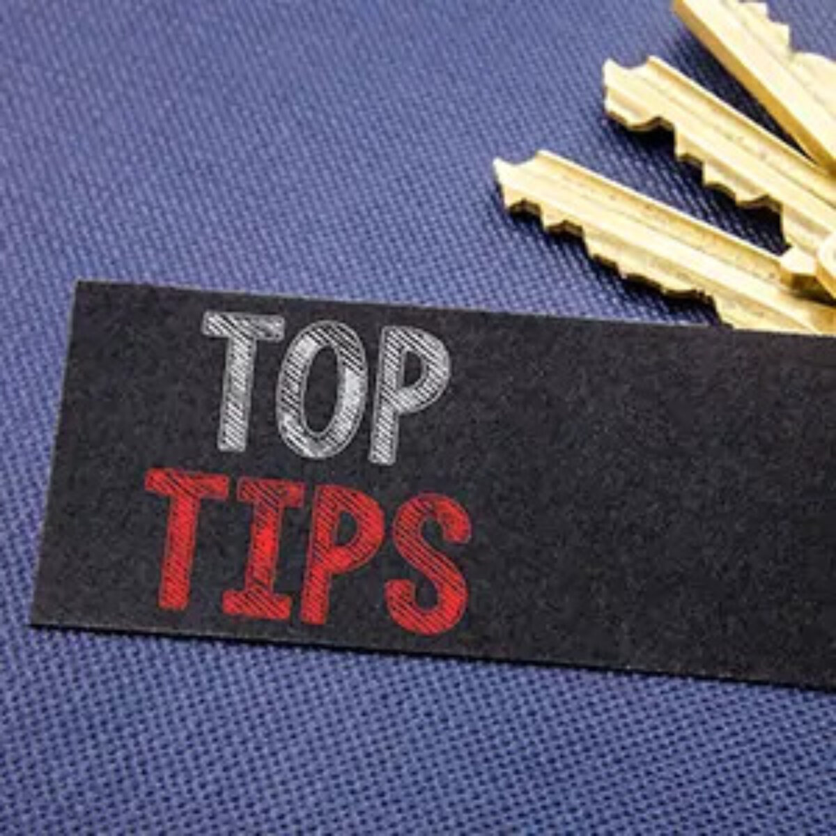 Piece of fabric with 'top tips' written on it in front of a set of three gold keys