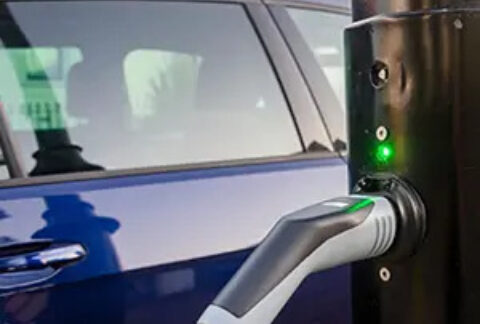 Car next to roadside electric car charging point