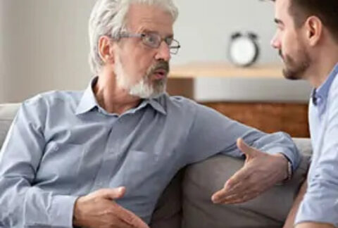Two businessmen sitting on sofa talking