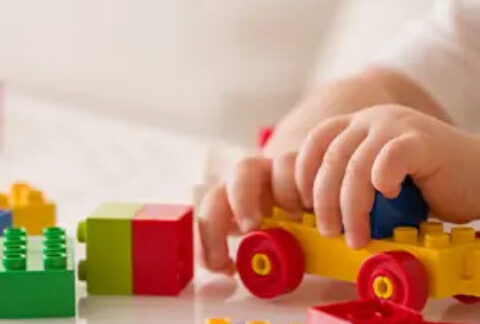 Child playing with Lego at table