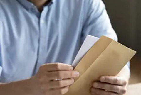 Businessman at desk opening letter