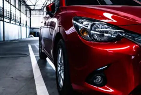 Close up of the side of a red car and the road