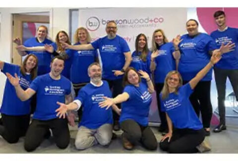 Benson Wood & Co team posing in the office wearing Scottish Huntington's Association t-shirts