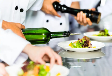 Chefs garnishing dishes in restaurant kitchen