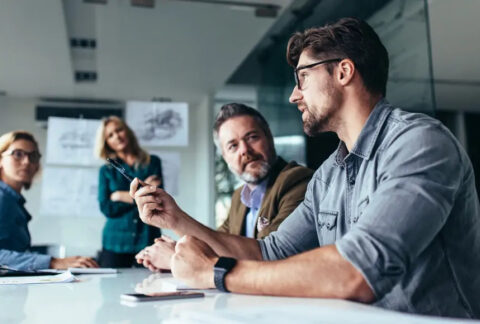 Businesspeople sat around table in meeting discussing