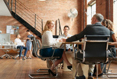 Businesspeople sitting around table at meeting in modern office
