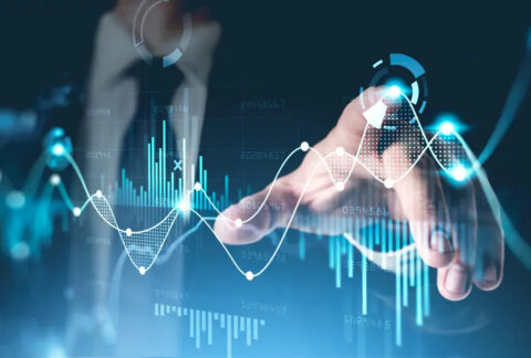 Businessman pointing at overlaid graph images