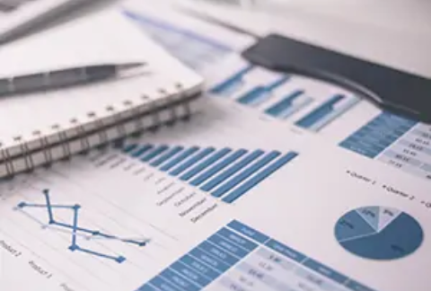 Notebook and document showing graphs and charts on desk